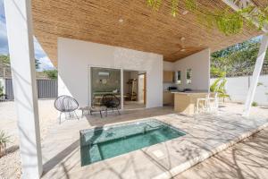 an outdoor patio with a swimming pool and a house at Antemar Guest, Beach bungalow near Conchal in Brasilito
