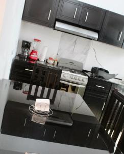 a kitchen with black cabinets and a stove top oven at CASA LIZ & FER in Zacatlán