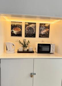 a kitchen counter with a microwave and pictures on the wall at Velvet Prime Stay in Lisbon