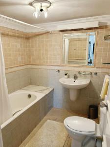 a bathroom with a tub and a toilet and a sink at Hotel Plaza la marsa in Tunis