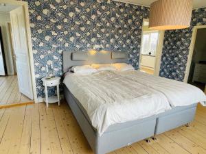 a bedroom with a bed with blue and white wallpaper at 8 person holiday home in Moheda-By Traum in Moheda
