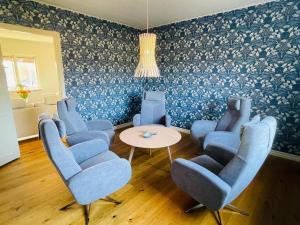 a waiting room with blue chairs and a table at 8 person holiday home in Moheda-By Traum in Moheda