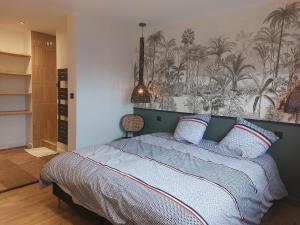 a bedroom with a bed with a tropical mural on the wall at Maison à ROSCOFF avec vue mer in Roscoff