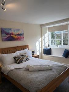 a bedroom with a large bed with a window at The Cleave Inn in Lustleigh