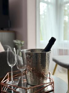 a metal bucket with a bottle in it next to two wine glasses at The Cleave Inn in Lustleigh