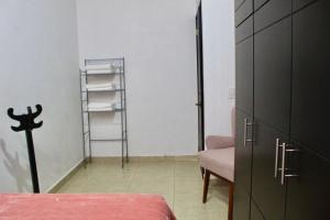 a bedroom with a bed and a chair and a closet at CASA LIZ & FER in Zacatlán +2 photos