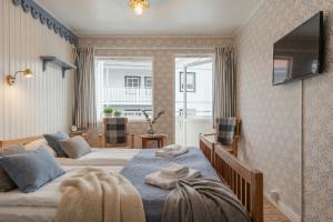 a bedroom with two beds and a television on the wall at Ekenäs Havshotell Koster in Sydkoster