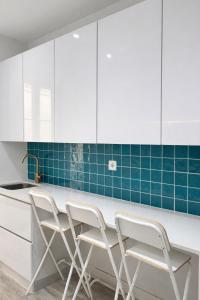 a kitchen with white cabinets and blue tiles at Velvet Prime Stay in Lisbon