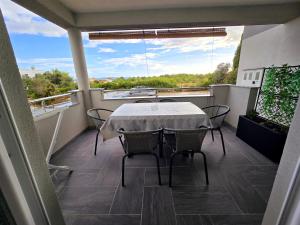 a patio with a table and chairs on a balcony at Apartman Jadranka in Vir
