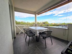 a patio with a table and chairs on a balcony at Apartman Jadranka in Vir +10 photos