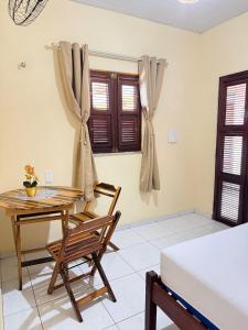 a room with a table and a chair and a bed at Pousada ExtraLar in Fortaleza