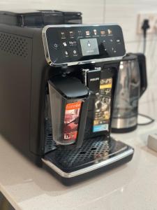 a coffee maker with two cell phones on top of it at SouthSide Apartment in Gaborone
