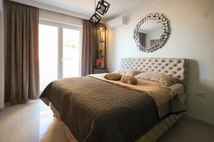 a bedroom with a large bed with a mirror on the wall at Djuric Apartmani in Zaječar