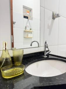 a bathroom with a sink and two vases on a counter at Pousada ExtraLar in Fortaleza +46 photos