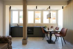 a kitchen with a table and chairs and windows at Djuric Apartmani in Zaječar