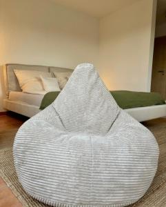 a white wicker chair in a living room with a couch at Modernes Studio mit Balkon & Seeblick am Biggesee in Olpe
