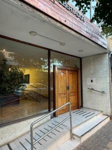 a store front with a wooden door and stairs outside at Hermoso Depto Almarza in Rancagua