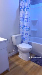 a bathroom with a toilet and a shower curtain at Cozy Urban Hideout in Saskatoon