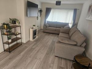 a living room with a couch and a table at Leasowe House in Bidston