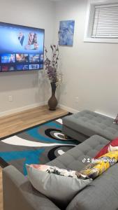a living room with a couch and a flat screen tv at Cozy Urban Hideout in Saskatoon +3 photos