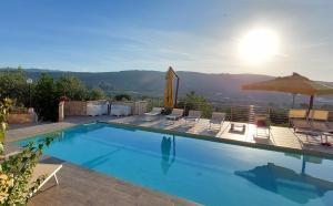 a swimming pool with chairs and an umbrella at Liberato Puglia Vacanze in Peschici