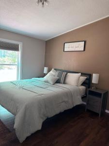 a bedroom with a large bed and a window at Sugar Maple Getaway in Gaylord
