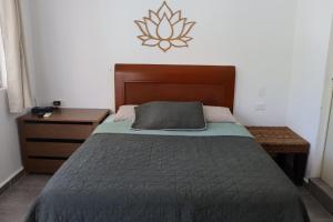 a bedroom with a bed and a wooden headboard at CASA JARDIN in Cancún