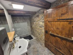 a bathroom with a toilet and a wooden door at Casa Verde in Cerişor