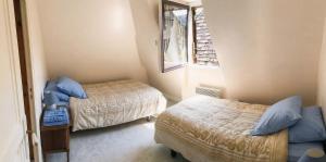 a small room with two beds and a window at La Familiale, Aile du Château de Busqueilles à Autoire, 3 chambres, 3 SDB, vue parc & calme in Autoire