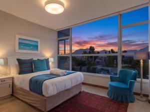 a bedroom with a bed and a large window at Coastal Condo Strand in Strand