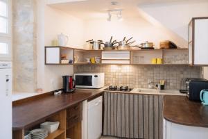 a kitchen with a counter top with a microwave at La Familiale, Aile du Château de Busqueilles à Autoire, 3 chambres, 3 SDB, vue parc & calme in Autoire