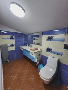 a blue and white bathroom with a toilet and a sink at Apartment 4 by Villa Ceni in Elbasan +5 photos