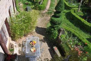 a bowl of fruit on a table in a garden at La Familiale, Aile du Château de Busqueilles à Autoire, 3 chambres, 3 SDB, vue parc & calme in Autoire