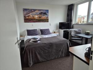 a bedroom with a bed and a desk with a desk at B&B Marijke in De Koog