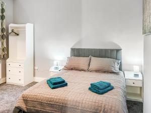 a bedroom with a bed with two blue pillows on it at Poppy - Uk49361 in Bridlington