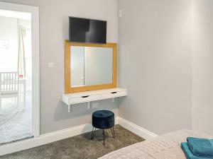 a bedroom with a mirror and a tv on a wall at Poppy - Uk49361 in Bridlington