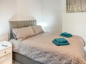 a bed with two green towels on top of it at Poppy - Uk49361 in Bridlington