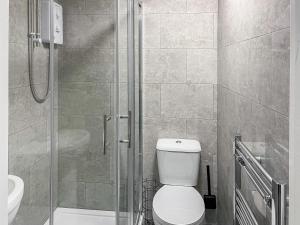 a bathroom with a shower with a toilet and a sink at Poppy - Uk49361 in Bridlington +2 photos