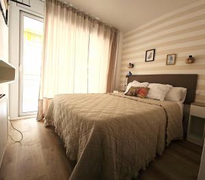 a bedroom with a large bed with a window at Residencial Colibrí in Cambrils