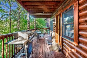 a porch of a log cabin with a grill on it at 2mils Dollywood, Resort Pool, King Bed, SL6 in Pigeon Forge