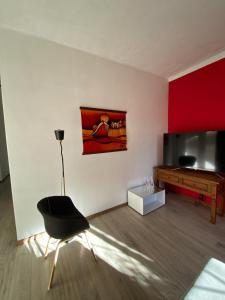 a living room with a black chair and a television at Casa Uruguay in Piriápolis