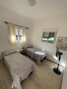 a bedroom with two beds and a lamp in it at Casa Uruguay in Piriápolis
