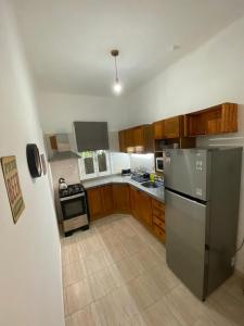a kitchen with wooden cabinets and a stainless steel refrigerator at Casa Uruguay in Piriápolis