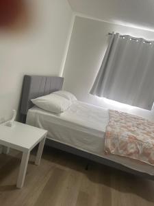 a bedroom with a bed and a white table at Your private room CozyVibe in Edmonton