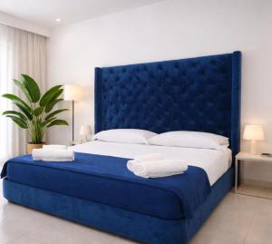 a blue bed with white sheets and towels on it at ALBACHIARA INN Residence Apartments in Ameglia