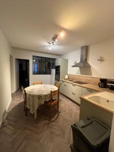 a kitchen with a table and chairs in a kitchen at Gite le Sainte Mère Eglise in Sainte-Mère-Église