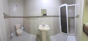 a white bathroom with a sink and a toilet at Hotel Mexico in Cancún