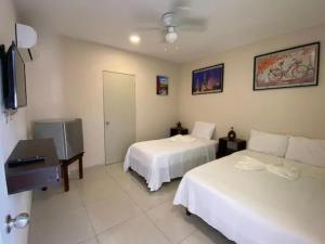 a hotel room with two beds and a television at Hotel Mexico in Cancún +1 photo