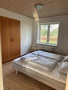 ein großes Bett in einem Schlafzimmer mit Fenster in der Unterkunft Dejrupvej in Ovtrup