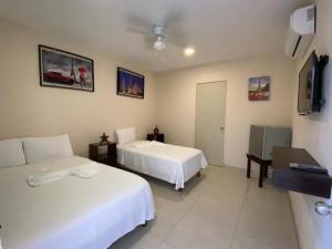 a hotel room with two beds and a flat screen tv at Hotel Mexico in Cancún
